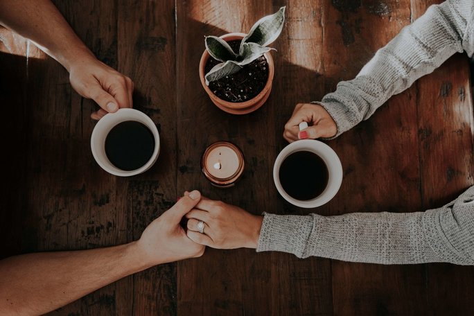 people holding hands with coffee
